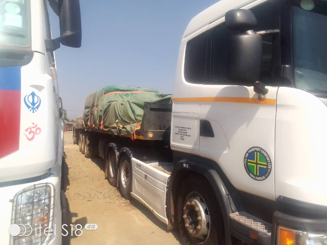 TTC Scania truck pulling green-covered cargo